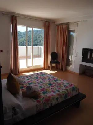 a bedroom with a bed and a large window at Brisas de Sierra Calderona in Gilet