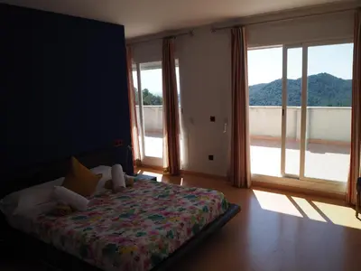 a bedroom with a bed and a large window at Brisas de Sierra Calderona in Gilet