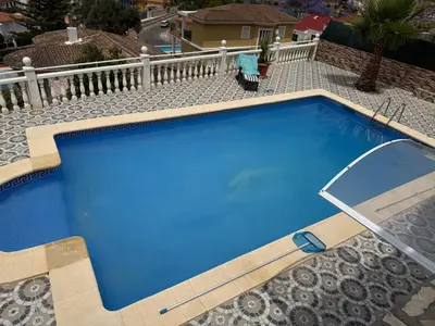 a large blue swimming pool on top of a house at Villa avec superbe vue in Cullera