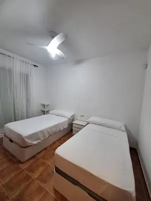 a bedroom with two beds and a ceiling fan at Townhouse with pool next to the City of Arts in Valencia
