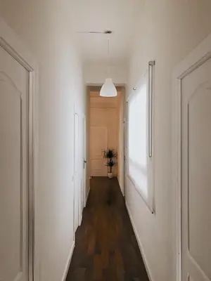 a hallway with white walls and a wooden floor at Welcome to your Home in Valencia