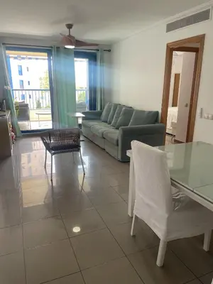 a living room with a couch and a table and chairs at Patacona beach apartment in Valencia