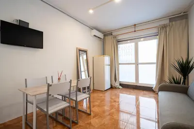 a living room with a table and chairs and a refrigerator at Loft Economico Cerca del Centro 1 Domitorio y Sofa cama 4pax AC in Valencia