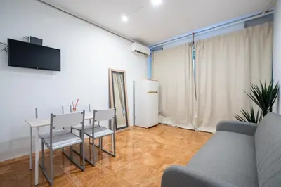 a living room with a couch and a table and chairs at Loft Economico Cerca del Centro 1 Domitorio y Sofa cama 4pax AC in Valencia
