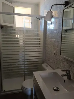 a bathroom with a toilet and a sink and a mirror at Cozy Beachside Apartment in Tavernes de Valldigna