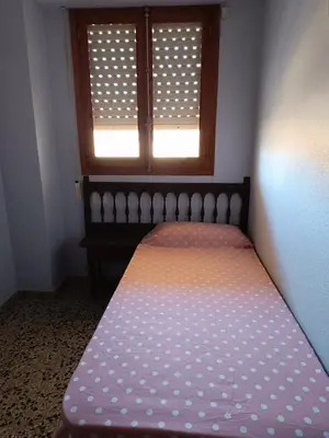 a bed in a room with a window at Cozy Beachside Apartment in Tavernes de Valldigna
