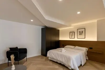 a bedroom with a bed and a chair at Boutique Room - One Tower in Valencia