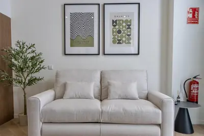 a couch in a living room with two pictures on the wall at Boutique Room - One Tower in Valencia