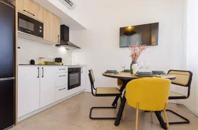 a kitchen with a table and yellow chairs in a kitchen at Naturaloft in Valencia