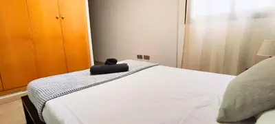 a bed with a black object on top of it at Apartamento cerca Playa in Puerto de Sagunto