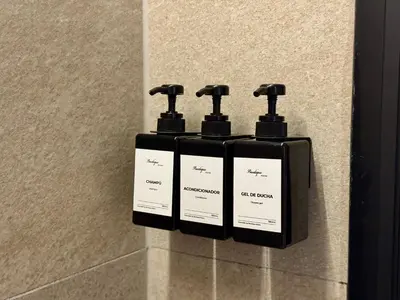 three bottles of soap on a wall in a bathroom at Boutique Room - Plaza Tower in Valencia