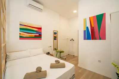 a bedroom with a bed and two paintings on the wall at Loft Centrico 2 pax Poyector TV in Valencia