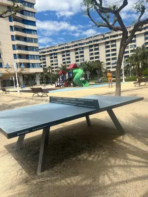 a ping pong table in front of a park at Beachfront Family Appartment with Pool in Valencia
