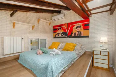 a bedroom with a bed and a painting on the wall at La Casa de las CestaS in Valencia