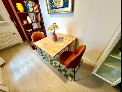 a dining room table with two chairs and a vase with flowers at La Casa de las CestaS in Valencia