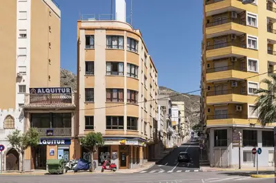 a tall building on a city street with buildings at Estirpe, 4-7 in Cullera