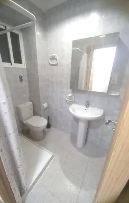 a white bathroom with a toilet and a sink at Estirpe, 4-7 in Cullera