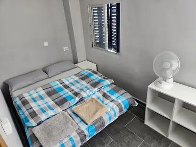 a small bedroom with a bed and a fan at Cosy house near the castle in Cullera