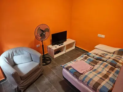 a bedroom with a bed and a fan and a chair at Cosy house near the castle in Cullera