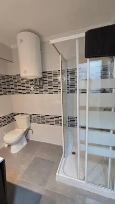 a bathroom with a toilet and a glass shower at Apartamento Musical in Cullera