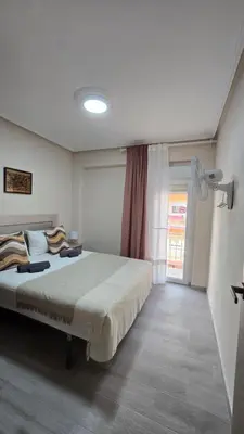 a bedroom with a large bed and a window at Apartamento Musical in Cullera