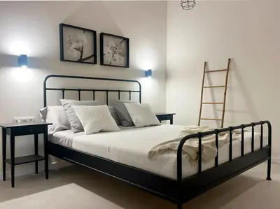 a bedroom with a black bed with white pillows and a ladder at Apartamento Estilo in Valencia