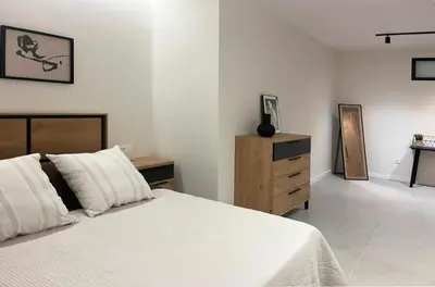 a white bedroom with a bed and a dresser at Apartamento Estilo in Valencia
