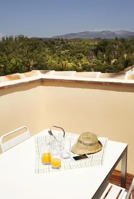 a table with two glasses of orange juice on a balcony at El Rincon De Jara in Caudiel