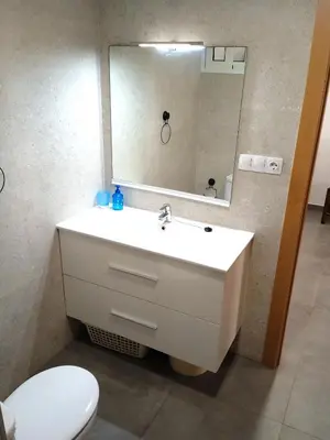a bathroom with a sink and a mirror and a toilet at Nautic, 4-I in Cullera