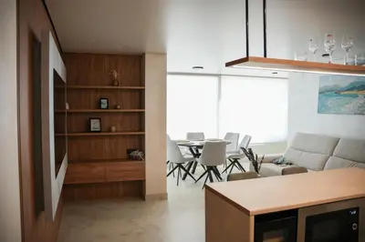 a kitchen and living room with a table and chairs at Sucro Playa Apartment in Cullera