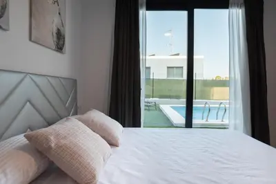 a bedroom with a bed and a view of a pool at Casa Blanca - Villa con piscina in Chiva