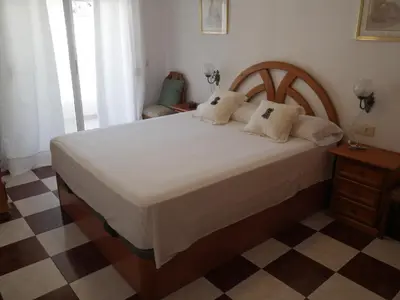 a bedroom with a large white bed and a checkered floor at Navarrete, 4-20 in Cullera