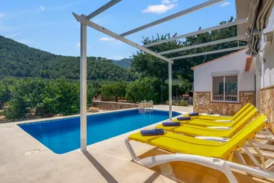a group of yellow lounge chairs next to a swimming pool at Lux Villa with Heating Pool, Air Conditioning, Starlink & BBQ near Cullera Beach in Llaurí
