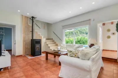 a living room with a white couch and a fireplace at Lux Villa with Heating Pool, Air Conditioning, Starlink & BBQ near Cullera Beach in Llaurí