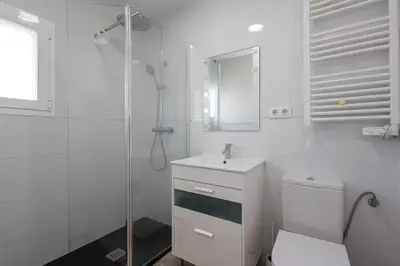 a white bathroom with a toilet and a shower at Villa Prestige Beach in Mareny Barraquetas