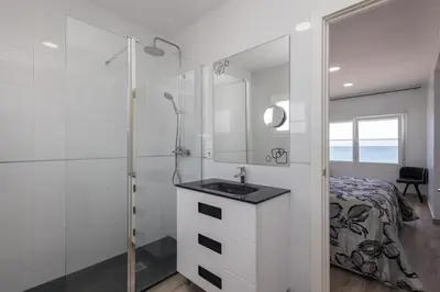 a bathroom with a shower and a sink and a bed at Villa Prestige Beach in Mareny Barraquetas