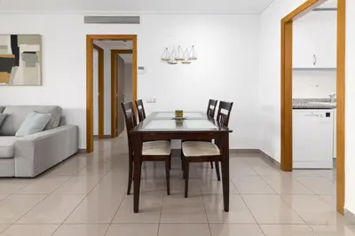 a dining room table and chairs in a living room at ApartUP Patacona Splendor in Valencia