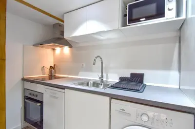 a white kitchen with a sink and a microwave at Alójate en el Puerto de Valencia 1 in Valencia