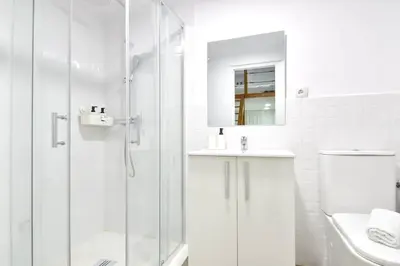 a white bathroom with a shower and a sink at Puerto de Valencia 2 in Valencia