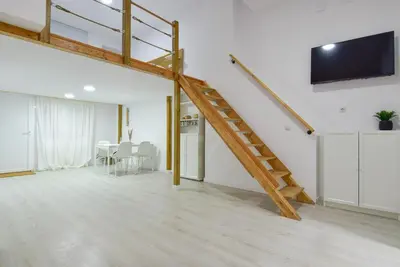 a living room with a staircase and a flat screen tv at Puerto de Valencia 2 in Valencia