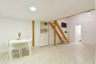 a white dining room with a table and a staircase at Puerto de Valencia 2 in Valencia