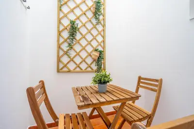 a wooden table and chairs with a potted plant on a wall at Maritim Loft Apartment in Valencia