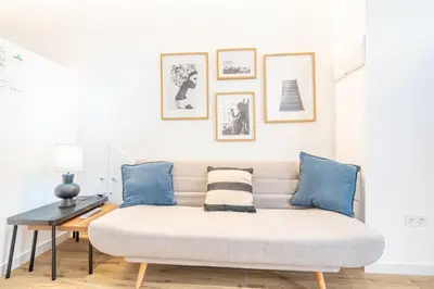 a white couch with blue pillows in a living room at Maritim Loft Apartment in Valencia