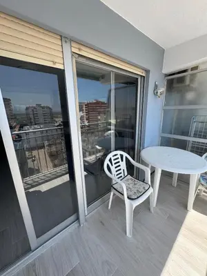 a balcony with a table and a chair and a table at apartamento con vistas en la playa de San Antonio in Cullera