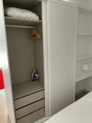 a closet with a white door and a bed at New luxury studio in the city center in Valencia