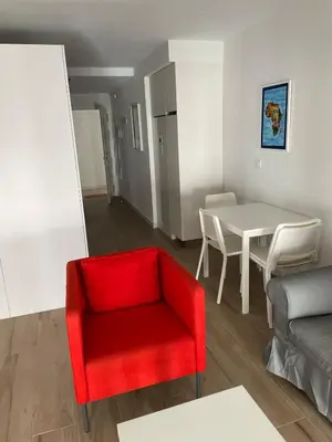 a living room with a red chair and a table at New luxury studio in the city center in Valencia