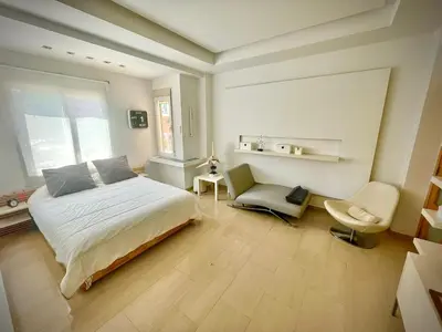 a bedroom with a bed and a chair and a window at luxury home vip valencia in Valencia
