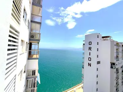 a view of the ocean from between two buildings at Isla de los Pensamientos in Faro de Cullera