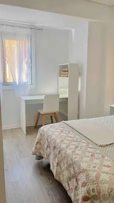 a bedroom with a bed and a desk and a chair at Cerca de Playa arenas con balcon in Valencia