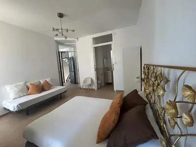 a bedroom with a white bed with colorful pillows at AmazINN Places Casa Calabuig Valencia Puerto - No Ascensor - in Valencia